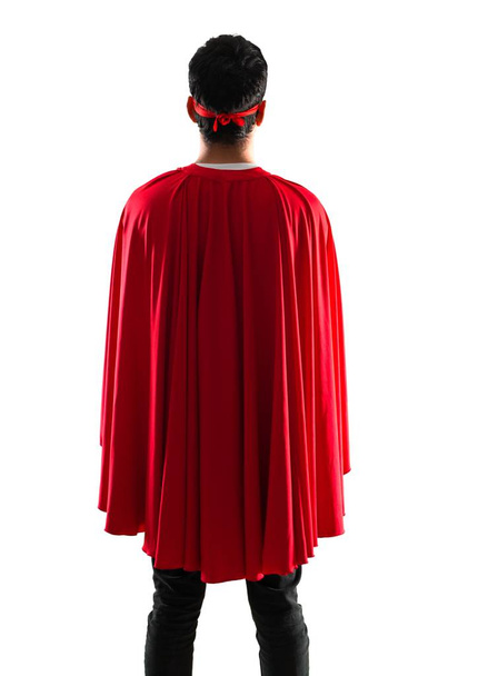 Uomo supereroe con maschera e mantello rosso in posizione posteriore su sfondo bianco isolato
 - Foto, immagini