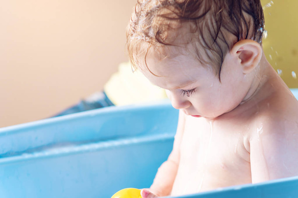 Μητέρα πλύσιμο το κεφάλι και τα μαλλιά μικρό αγόρι σε μπλε λουτρό. Υγιεινής επεξεργασίας νερού και στο σπίτι με το μωρό - Φωτογραφία, εικόνα