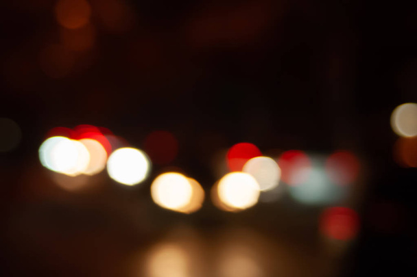 Blurred night background of city street road with bokeh effect. Abstract wallpaper for design and editing images. - Fotografie, Obrázek