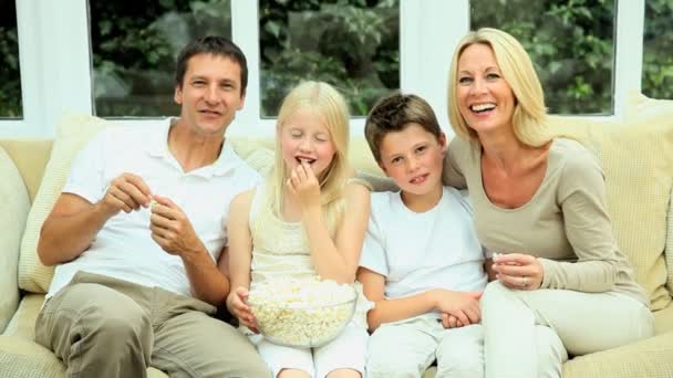 Ελκυστική οικογένεια απολαμβάνοντας τηλεόραση & ποπ κορν - Πλάνα, βίντεο