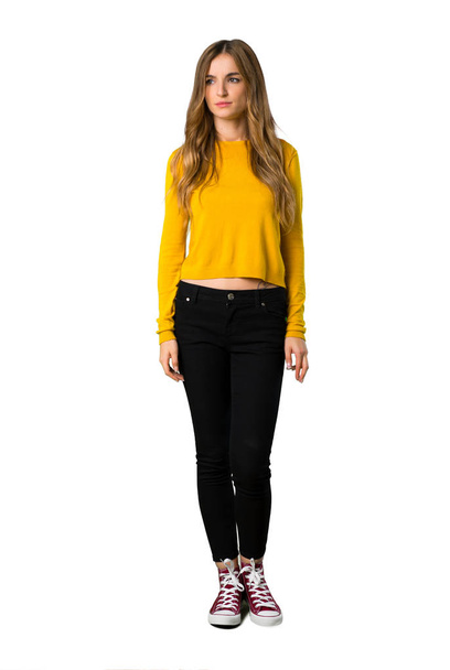 Un full-length shot di una giovane ragazza con maglione giallo sentirsi sconvolto su sfondo bianco isolato
 - Foto, immagini