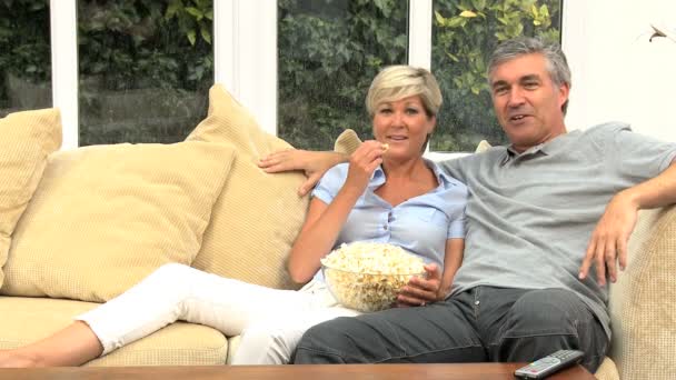 aantrekkelijke ouder paar tv-kijken met popcorn - Video