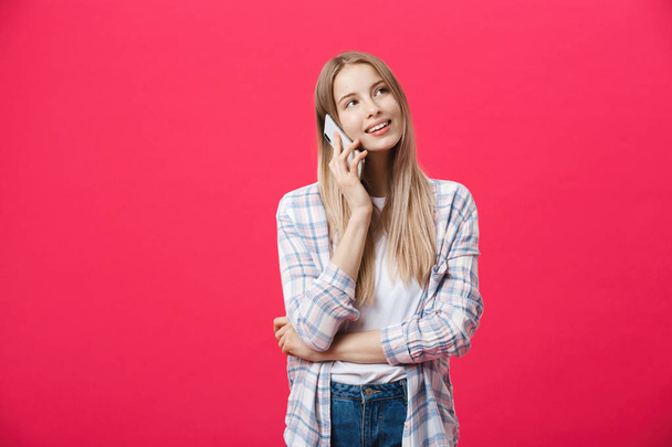 Joyeux jeune femme parlant sur téléphone mobile isolé sur fond rose - Photo, image