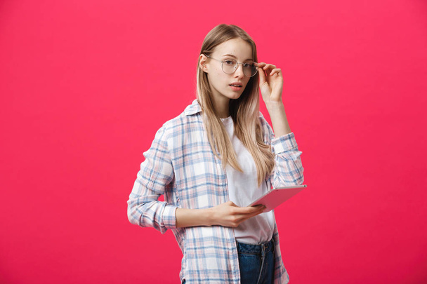 mladá podnikatelka držení tabletu a myslí na růžové backgrouond - Fotografie, Obrázek
