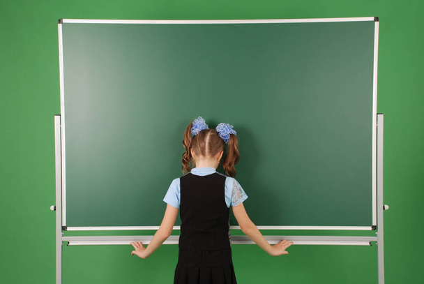 Schattig meisje schoolmeisje in de buurt van blackboard het concept van onderwijs en school leven - Foto, afbeelding