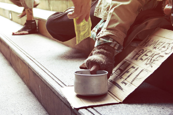 Könnten Sie bitte einem Obdachlosen helfen, der auf einem Gehweg in der Capticap-Stadt schläft?. - Foto, Bild