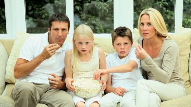 Fiatal család néz film együtt pattogatott kukorica - Felvétel, videó