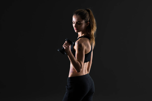 Sport vrouw maken van Gewichtheffen op donkere achtergrond - Foto, afbeelding