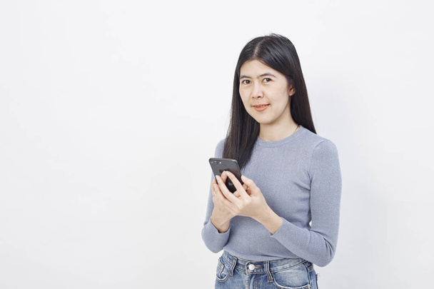 Азиатская женщина использовать мобильный телефон, улыбающаяся девушка-подросток сообщения на мобильном телефоне на белом фоне
 - Фото, изображение