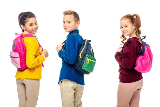 schoolchildren with multicolored backpacks smiling at camera isolated on white - Foto, Bild