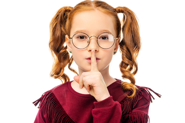 adorable child in glasses showing hush gesture and looking at camera isolated on white - Photo, Image