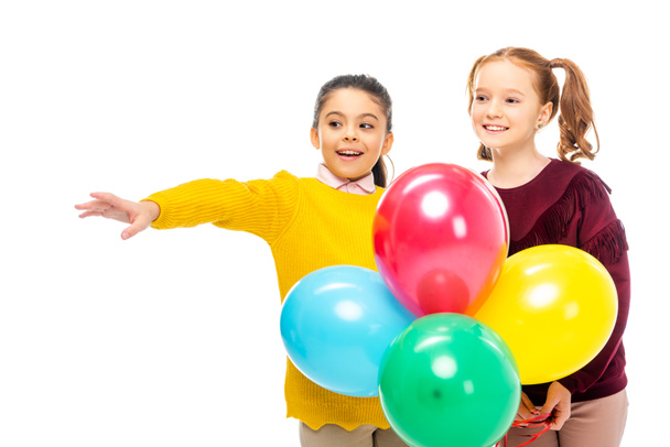 cheerful schoolgirls holding colorful balloons isolated on white - Foto, Bild