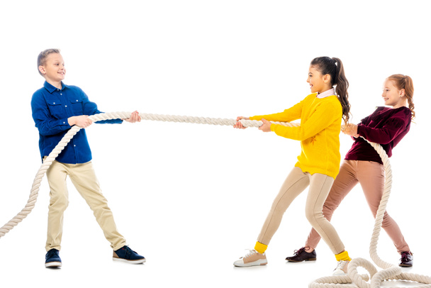 joyeux garçon et deux écolières tirant la corde isolé sur blanc
 - Photo, image