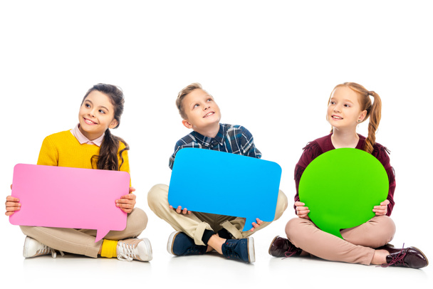 enfants gais assis et tenant des bulles de parole multicolores isolés sur blanc
 - Photo, image