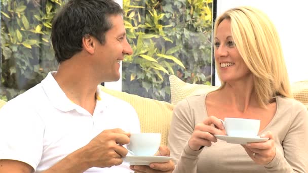 ελκυστικό ζευγάρι χαλαρωτικό με το φλυτζάνι του καφέ - Πλάνα, βίντεο