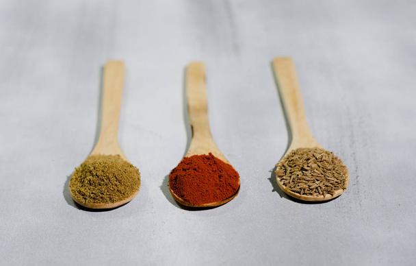 especias tpicas en tres cucharas de maderas por color comino semillas pimiento - Фото, изображение