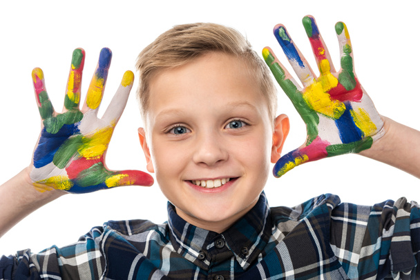 vista de cerca de chico lindo mirando a la cámara y mostrando las manos pintadas en pinturas de colores aislados en blanco
 - Foto, Imagen
