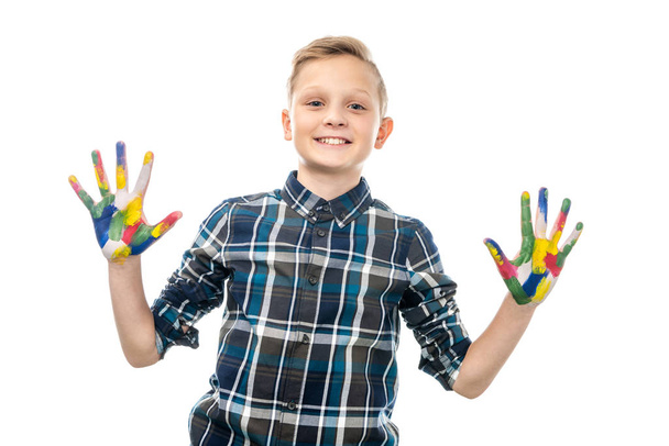 kameraya bakarak ve renkli boyalar üzerinde beyaz izole boyalı el gösterilen sevimli çocuk - Fotoğraf, Görsel