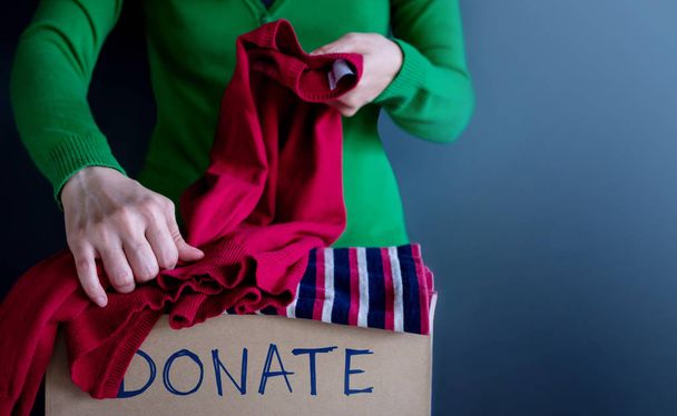 Koncept darování. Žena připravuje její použité staré oblečení do krabice darovat - Fotografie, Obrázek
