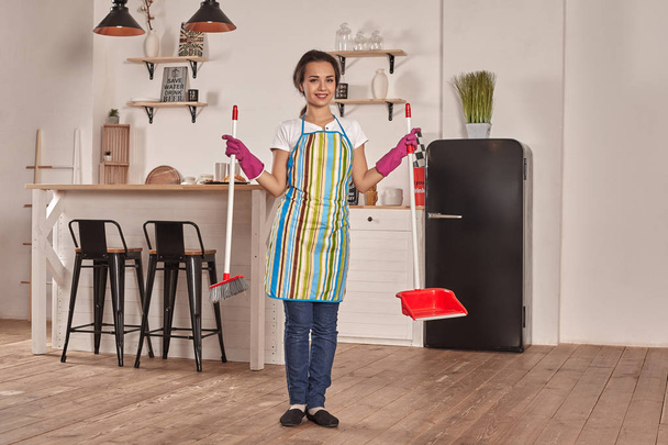 Jovem mulher varrendo chão na cozinha
 - Foto, Imagem