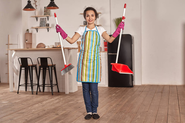 Jovem mulher varrendo chão na cozinha
 - Foto, Imagem