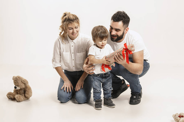 happy family with kid sitting together and smiling at camera isolated on white - Foto, Bild