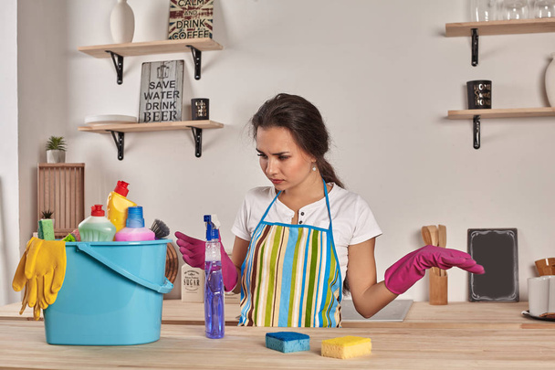 schöne fröhliche brünette Frau in Handschuhen putzt moderne Küche - Foto, Bild