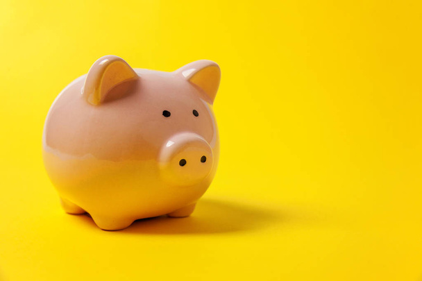 Pink piggy bank isolated on yellow colourful trendy modern fashion background. Saving investment budget wealth business retirement, financial, money, banking concept. Copy space - Foto, immagini