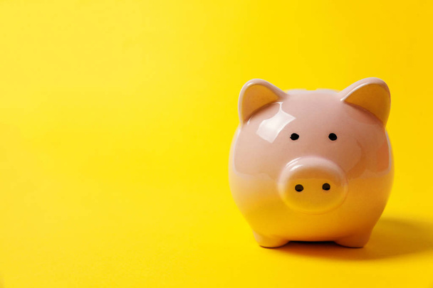 Vaaleanpunainen säästöpossu eristetty keltainen värikäs trendikäs moderni muoti tausta. Säästää sijoitusbudjetin varallisuutta liiketoiminnan eläkkeelle, rahoitus, raha, pankkikonsepti. Kopioi tila
 - Valokuva, kuva