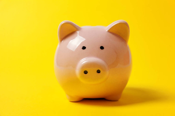 Pink piggy bank isolated on yellow colourful trendy modern fashion background. Saving investment budget wealth business retirement, financial, money, banking concept. Copy space - Photo, Image
