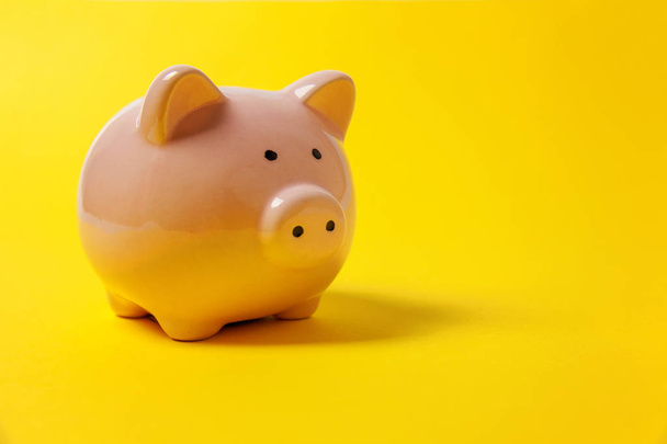 Pink piggy bank isolated on yellow colourful trendy modern fashion background. Saving investment budget wealth business retirement, financial, money, banking concept. Copy space - Foto, afbeelding