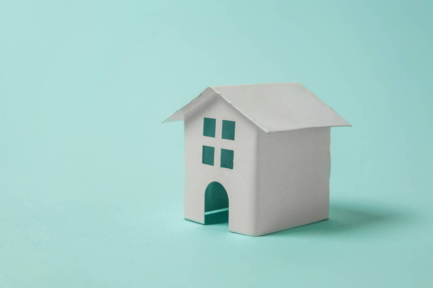 einfach Design mit Miniatur-weißes Spielzeughaus isoliert auf blauem pastellfarbenem trendigen Hintergrund. Hypothekenversicherungen Traumhaus Konzept. Kopierraum - Foto, Bild