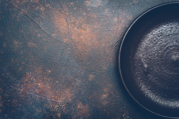 Empty brown plate (ceramic) on a dark background with a knife and fork. Copy space. - Foto, imagen