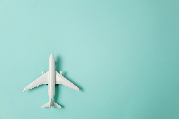 Egyszerűen lapos laikus design miniatűr játék modell repülőgép kék pasztell színes papír trendi alapon. Utazás repülővel nyaralás nyári hétvégén tengeri kaland utazás utazás jegy turné koncepciója - Fotó, kép
