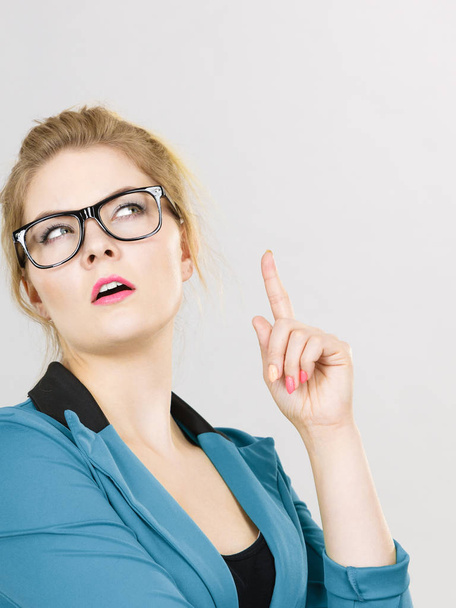 Business woman wearing blue jacket and eyeglasses intensive thinking finding great problem solution. - Zdjęcie, obraz
