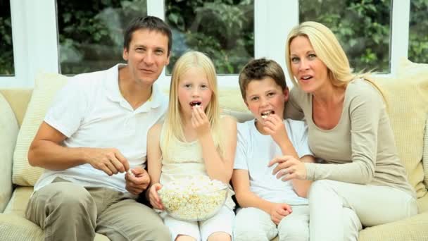 jonge familie kijken film samen met popcorn - Video