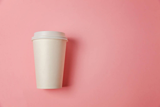 Simply flat lay design paper coffee cup on pink pastel colorful trendy background. Takeaway drink container. Good morning wake up awake concept. Template of drink mockup. Top view copy space - 写真・画像