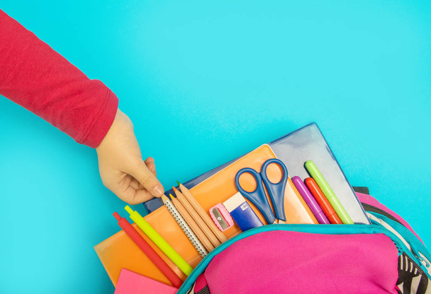 Back to school concept. Backpack with school supplies on colored background - Foto, immagini