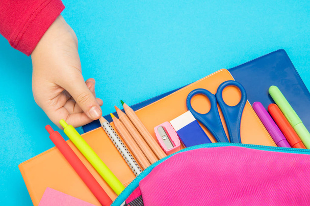 Back to school concept. Backpack with school supplies on colored background - Foto, immagini