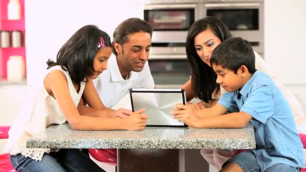 Familia étnica joven con tableta inalámbrica en la cocina
 - Imágenes, Vídeo