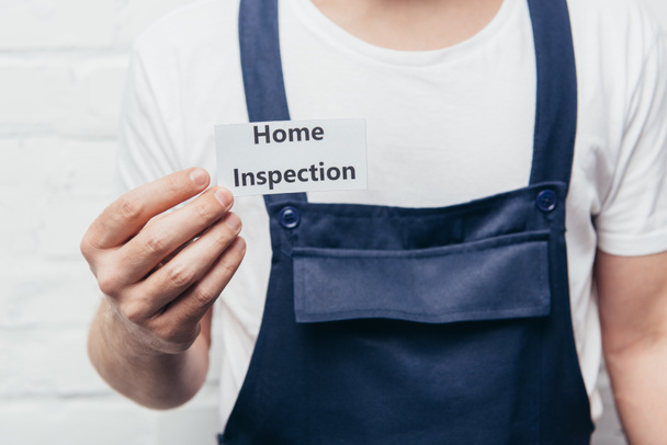 cropped image of male craftsman showing card with lettering home inspection  - Fotoğraf, Görsel