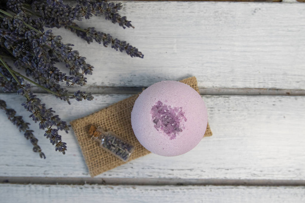 Natural cosmetics. Handmade lavender bath bombs and lavender flowers on white wooden planks - Fotó, kép