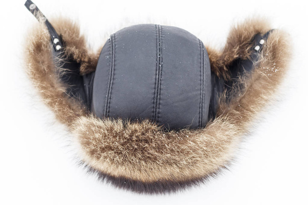 Γούνινο καπέλο χειμώνα για τους άνδρες, στο φυσικό χιόνι. εκεί είναι τονωτικό και close-up. - Φωτογραφία, εικόνα