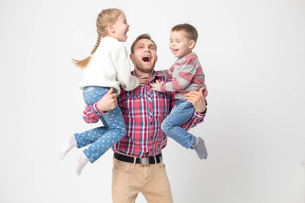Father with children having fun on a white background. Father holds daughter and son. - 写真・画像