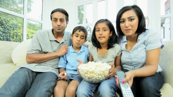 jonge etnische familie tv-kijken met popcorn - Video