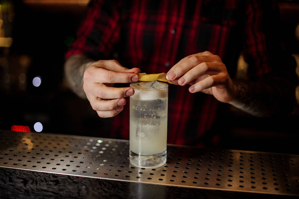 Barman decorating a glass of alcoholic lemonade drink - Foto, Bild