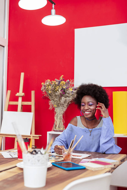 Stylish young woman holding her red phone while calling friend - Foto, Bild