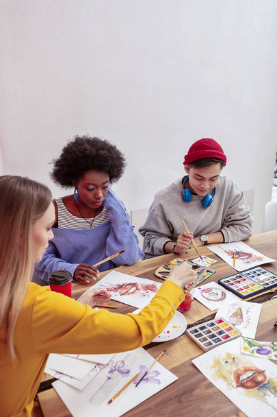 Three fashionable art students attending drawing class - Foto, imagen