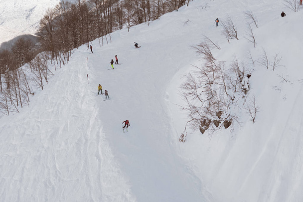 σκιέρ και snowboarders βόλτα σε πλαγιές βουνών ταξίδια-διακοπές χειμώνα το χιονοδρομικό θέρετρο - Φωτογραφία, εικόνα
