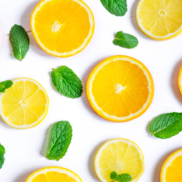 White background with lemon, orange slices and mint. Concept with fresh fruit. Lemon, Orange, Mint. View from above. Vitamin C Tea. - 写真・画像